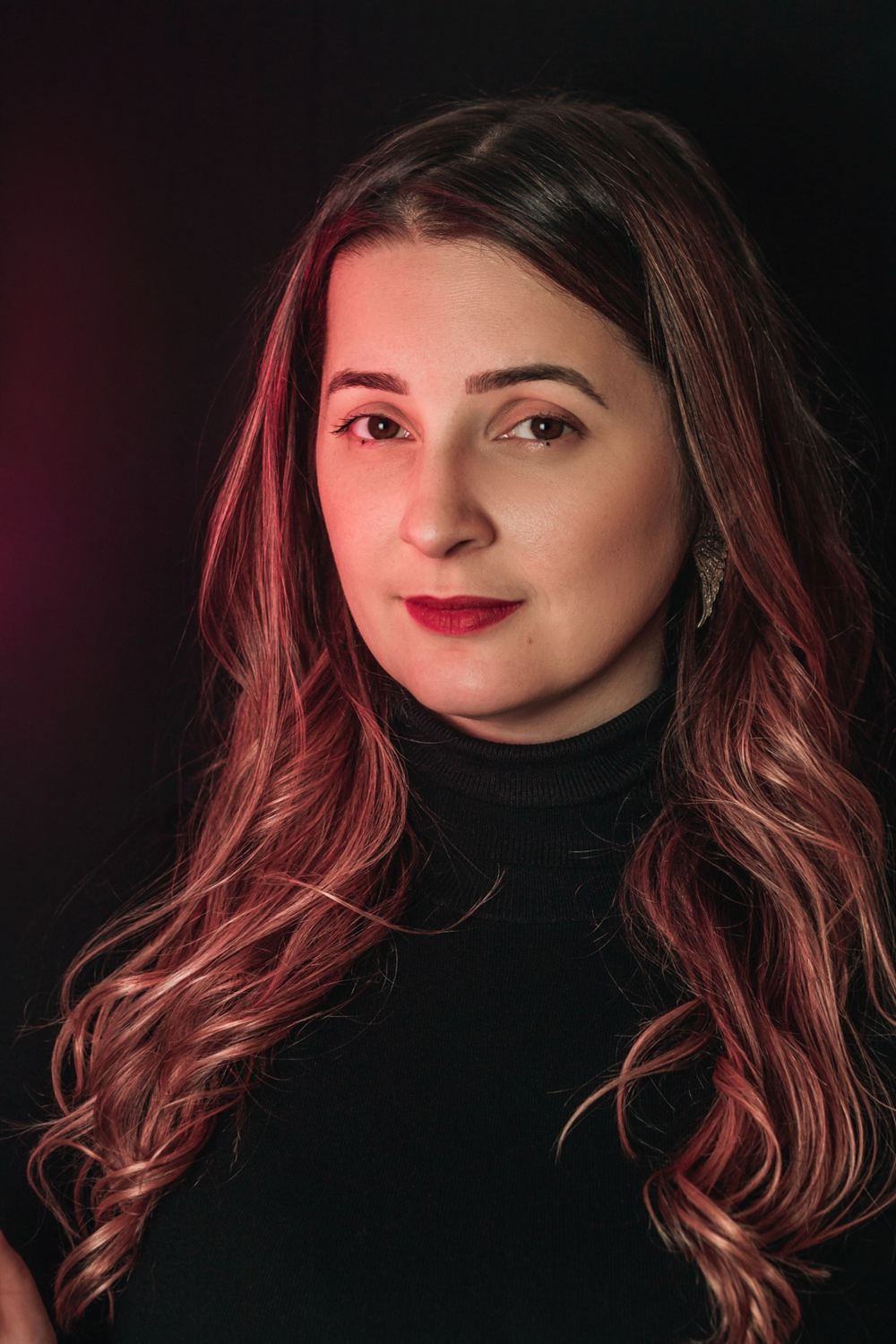 Retrato de Sephora Marchesini, com cabelo comprido ondulado e camisola preta, olhando para a câmara
